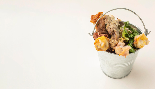 En hink full med mat som står på ett bord.