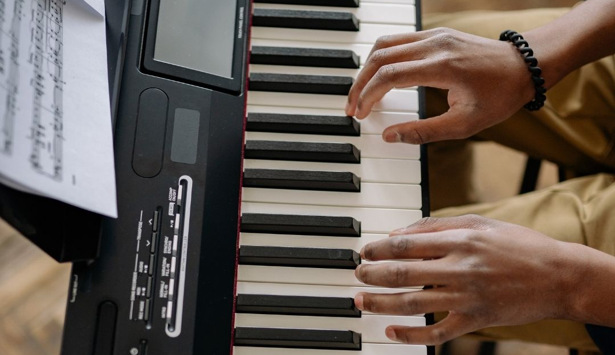 En person som spelar piano med noter.
