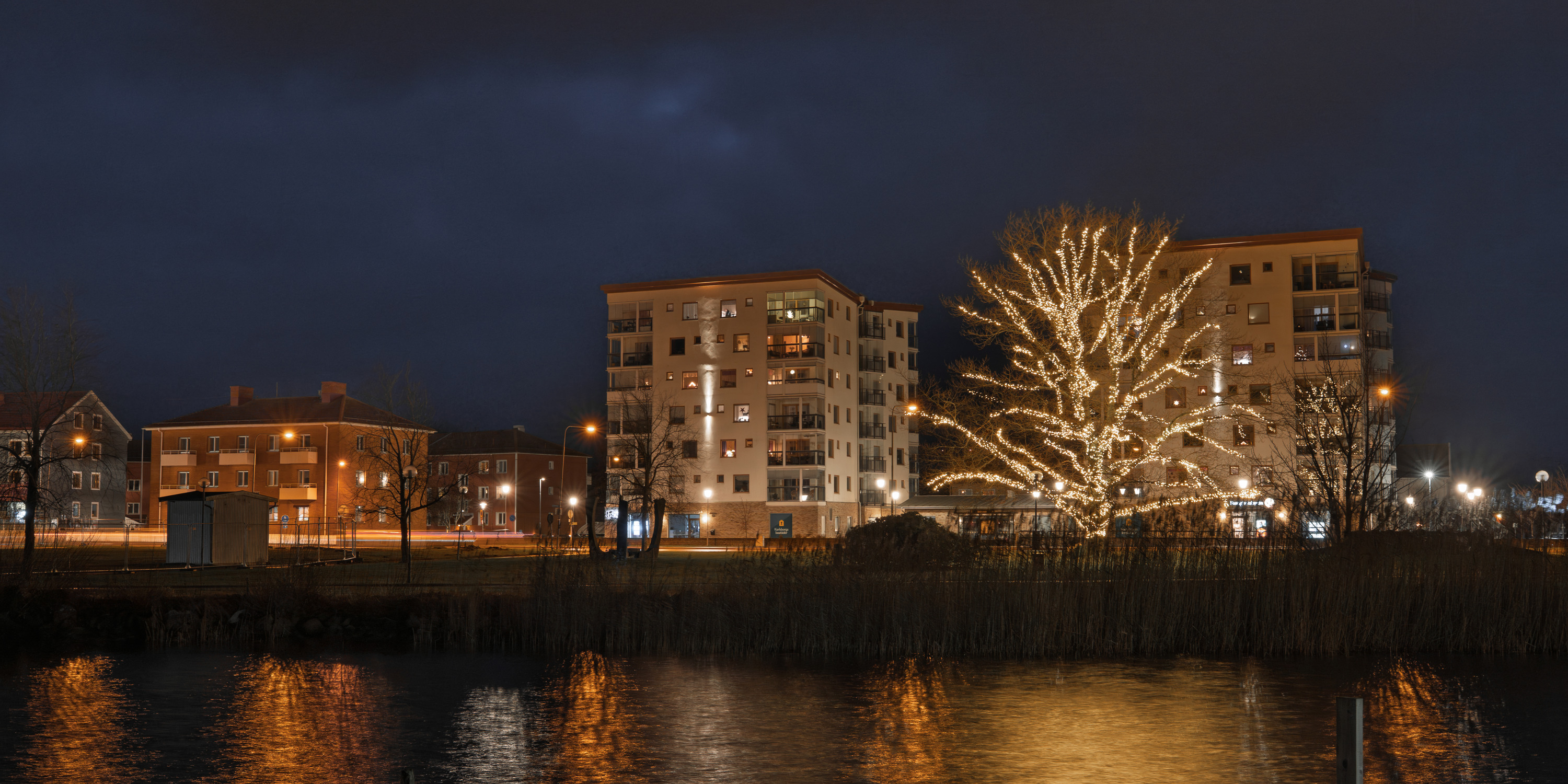 Belyst träd och höghus vid Strömmen Karlsborg