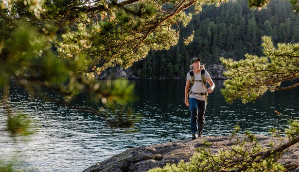 Person med packning vandrar på klippa.