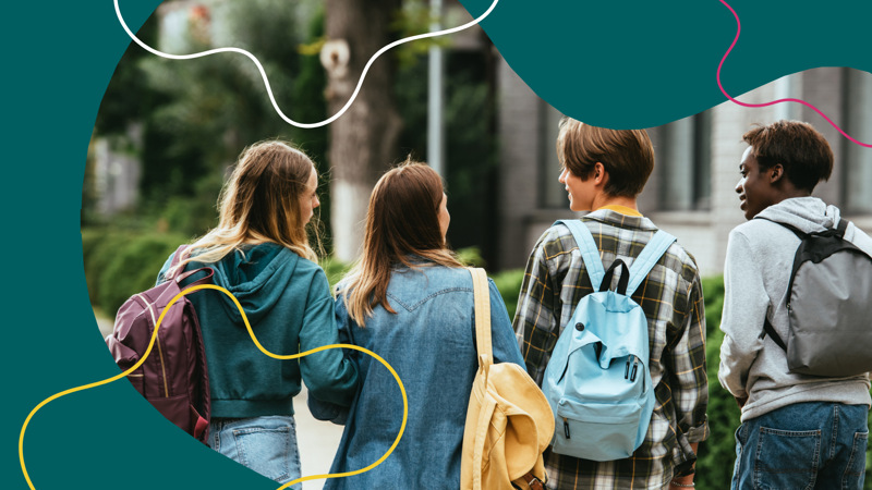 En grupp unga människor som går längs en gata.