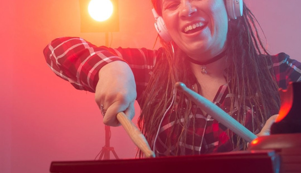 En kvinna med hörlurar som spelar ett musikinstrument.