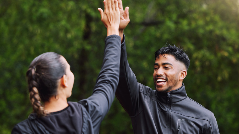Två personer som gör en high five, de ler.