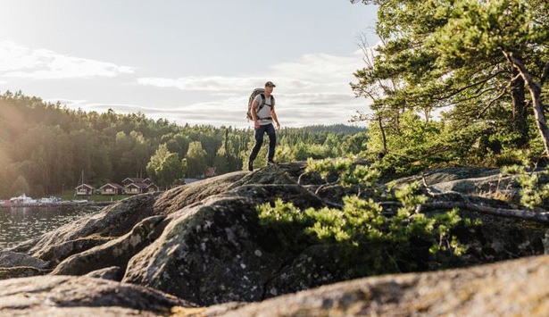 Person med packning vandrar på klippa.