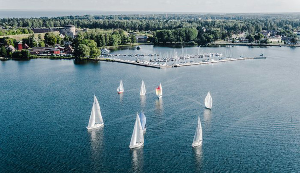 Flygbild segelbåtar på Vättern med stenbryggans båthamn i bakgrunden