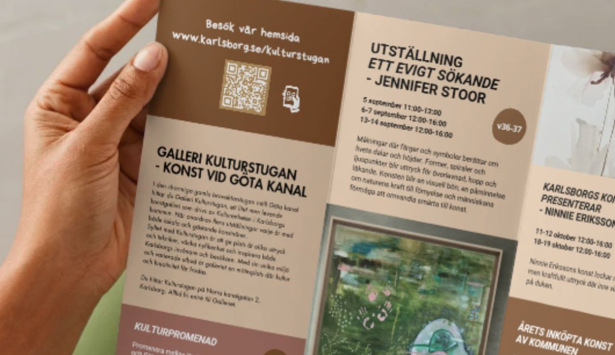 En person som håller upp en broschyr i sina händer.