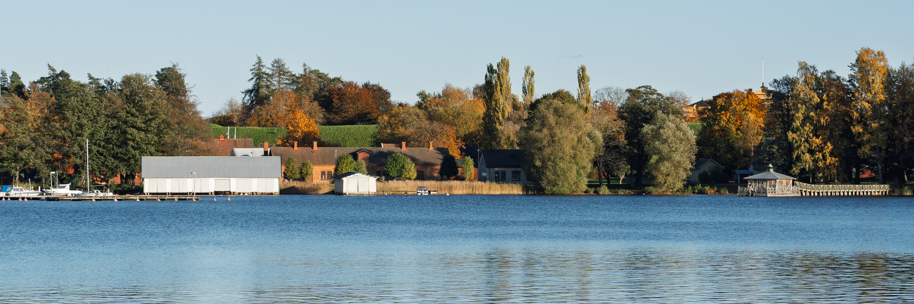 Sjön Vättern med stenbryggan och flytbastu i bakgrunden.