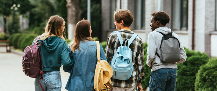 En grupp unga människor som går på en trottoar
