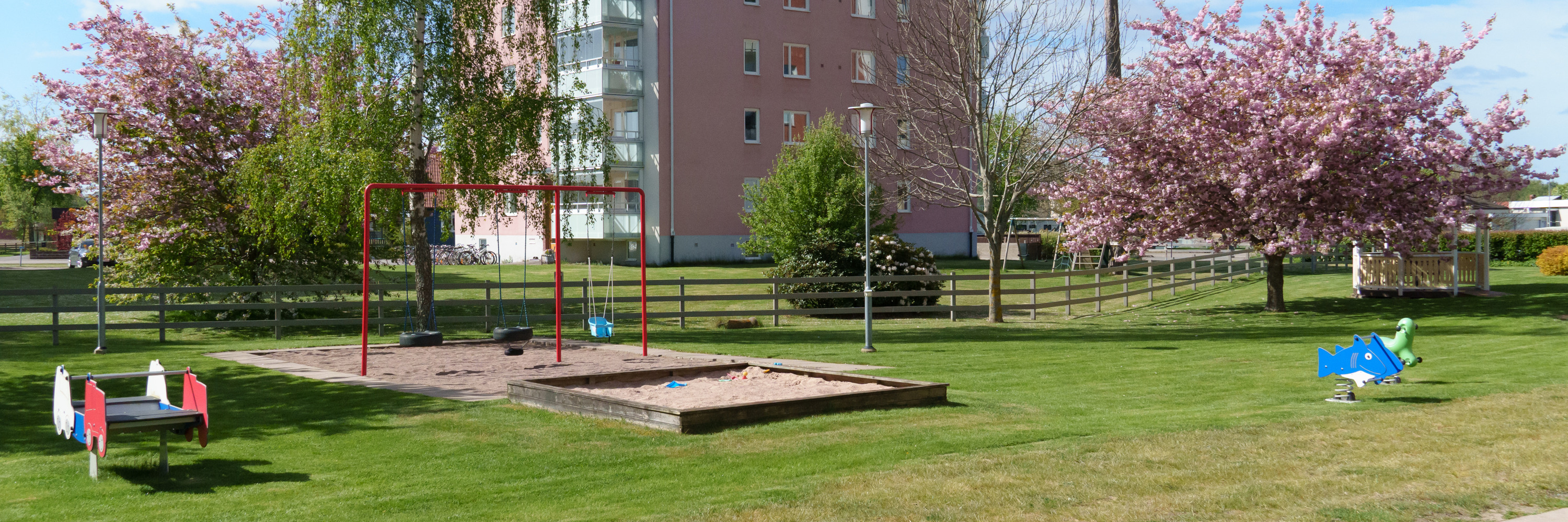 En lekplats med hyreshus i bakgrunden